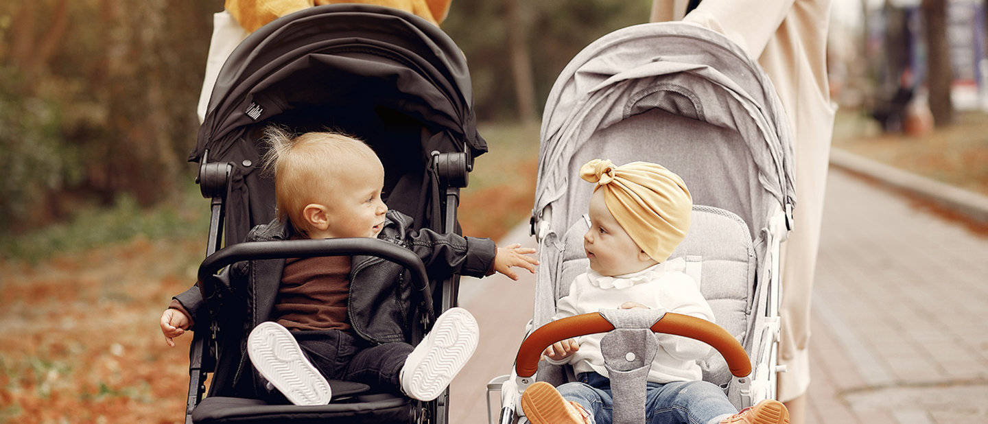 twee jonge kinderen in wandelwagens